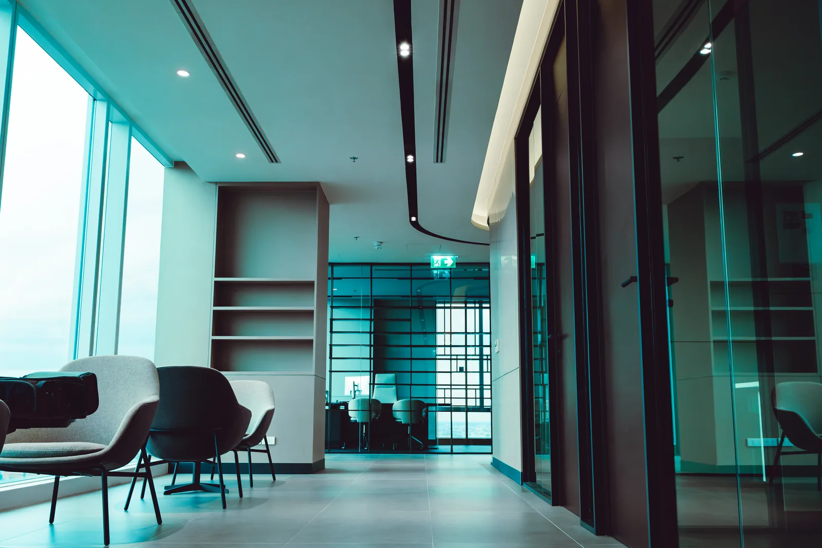 Office reception lounge with bookshelf joinery and a glass fronted meeting room