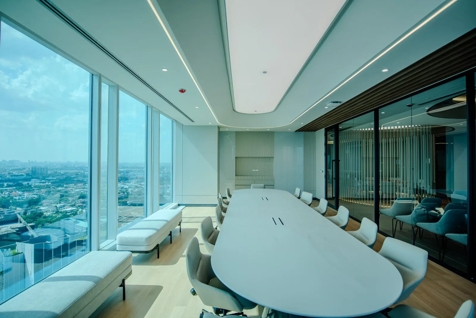 Boardroom table with skyline views and lounge seating beyond