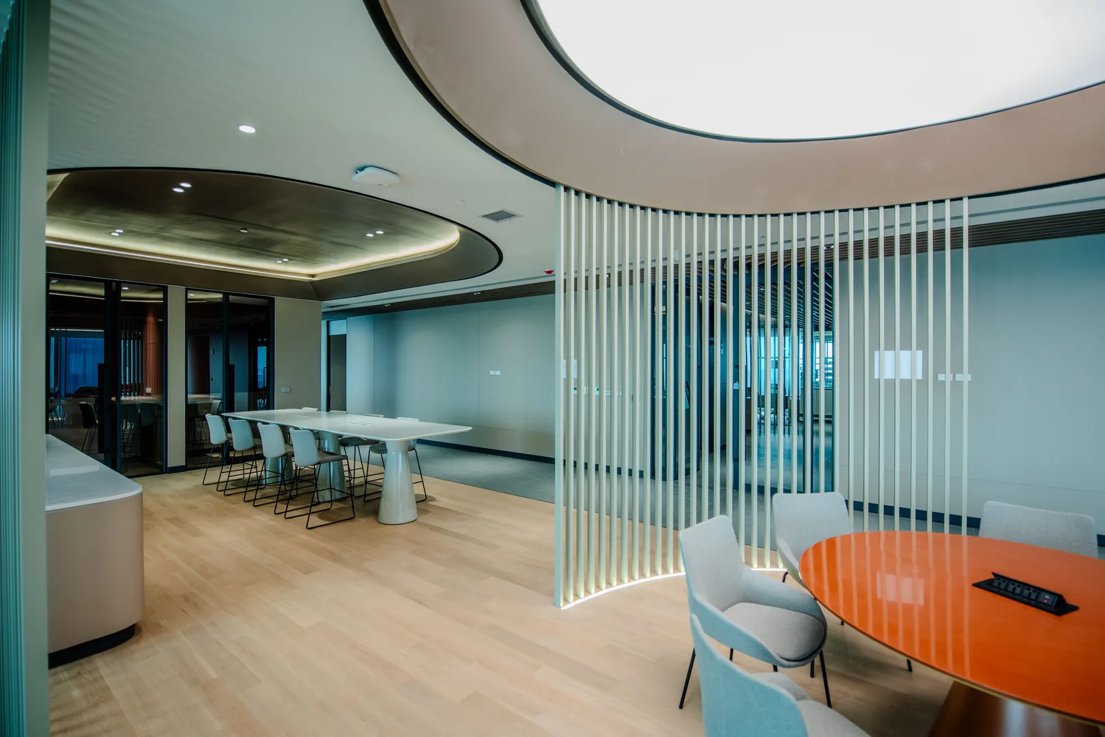 Open meeting area with a curved timber slat screen and lounge seating