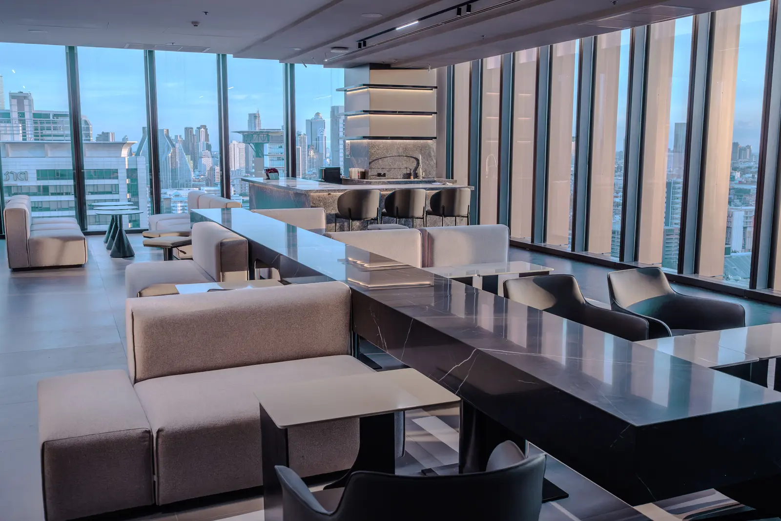 Long lounge table with pendant lighting and skyline view